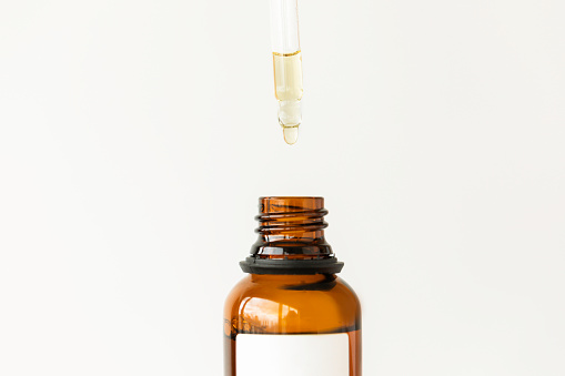 Beauty serum bottle with white mockup space in front of white background.