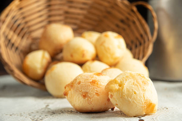 istock Cheese bread, Basket with cheese bread lying on a white lace tablecloth and accessories, dark background, selective focus. 1497475449
