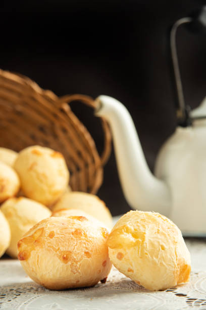istock Cheese bread, Basket with cheese bread lying on a white lace tablecloth and accessories, dark background, selective focus. 1497475462