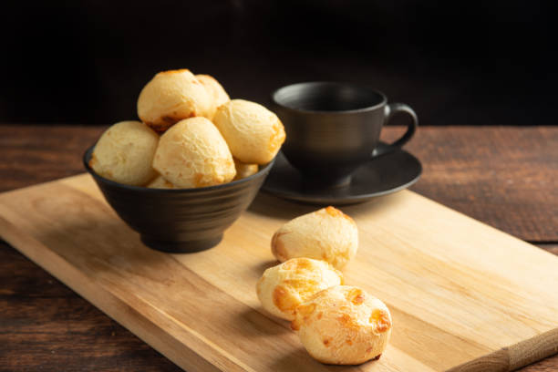 istock Cheese bread, Basket with cheese bread lying on rustic wood and black accessories, dark background, selective focus. 1497475464