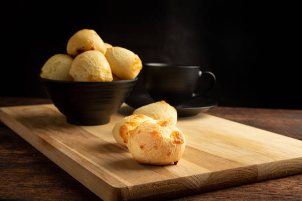 istock Cheese bread, Basket with cheese bread lying on rustic wood and black accessories, dark background, selective focus. 1497475477