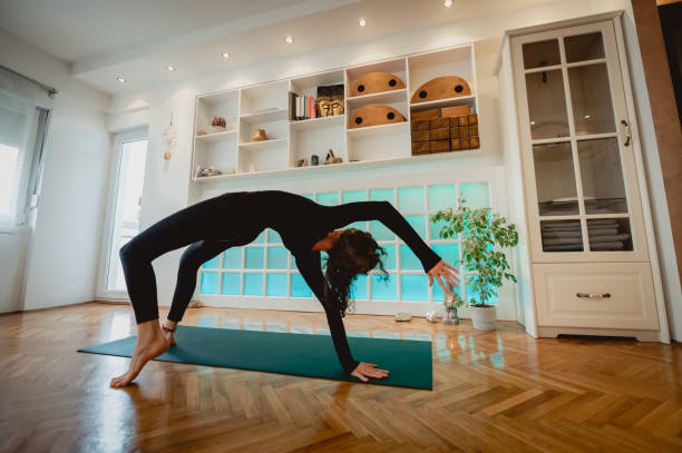 istock Dark haired girl with her back turned stretching in a bridge pose and balancing. 1497478604
