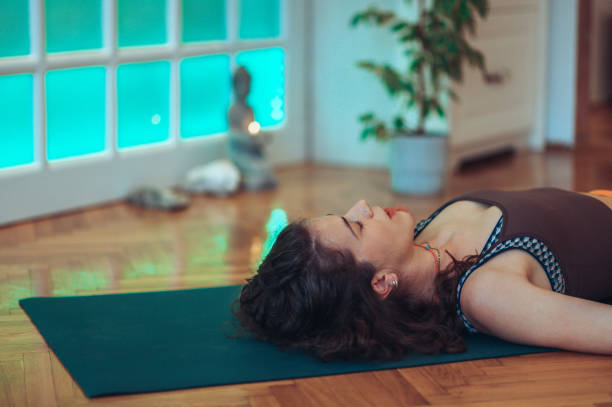 istock Young girl lying on a mat with her eyes closed while resting and breathing. 1497478609
