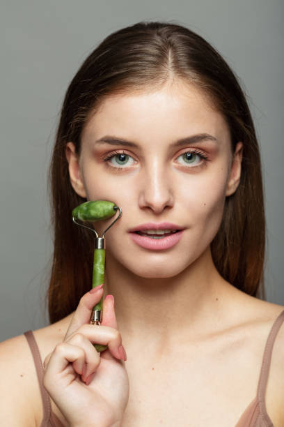 istock Young Woman applying jade roller for massaging her face 1497478674