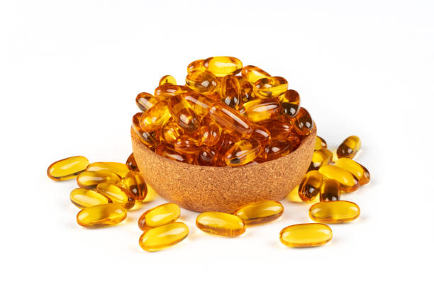 istock Cod liver oil omega 3 gel capsules in bowl isolated on white background 1497481446