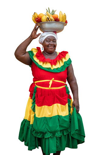 Happy smiling Palenquera fresh fruit street vendor typical of Cartagena, Colombia, isolated on white background. Cheerful Afro-Colombian woman in traditional clothing, Colombian culture and lifestyle.