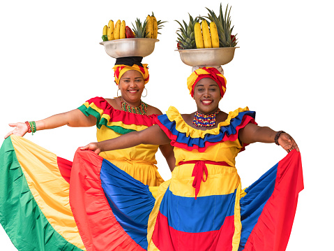 Cheerful Palenquera fresh fruit street vendors typical of Cartagena de Indias, Colombia, isolated on white background. Happy Afro-Colombian women in traditional clothing, Colombian culture and lifestyle.