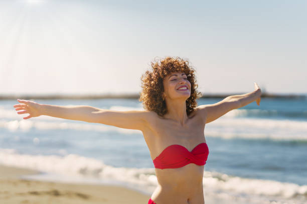 istock Happy woman in bikini standing on beach 1497486145