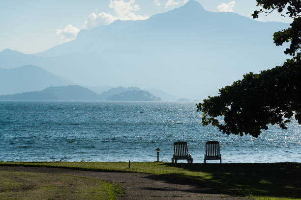 Beautiful beach in Angra do Reis, green coast of Rio de Janeiro. Tanguá Beach. Hills and mountains in the background on a sunny day. Crystal clear water. stock photo