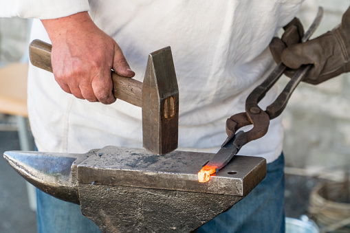 Blacksmith at work making horseshoe in Ukraine. Handmade craftmanship