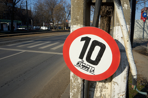 Bucharest, Romania - February 13, 2023: A 10 km/h speed limit sign for trams on Basarabia Boulevard where the tram tracks are in an advanced stage of deterioration.