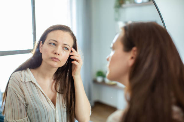 istock Young woman looking at a mirror at home 1497497810