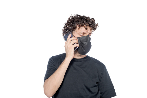Middle-aged man in a black cover-up talking with his smartphone, on a white background.