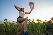 Jump high. Gen Z girl having fun in sunflower field.