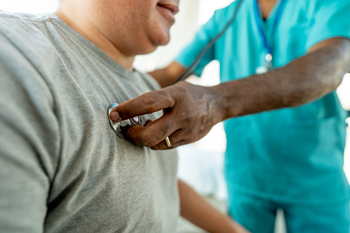 Hombre maduro revisando su presión arterial en el consultorio de un médico photo
