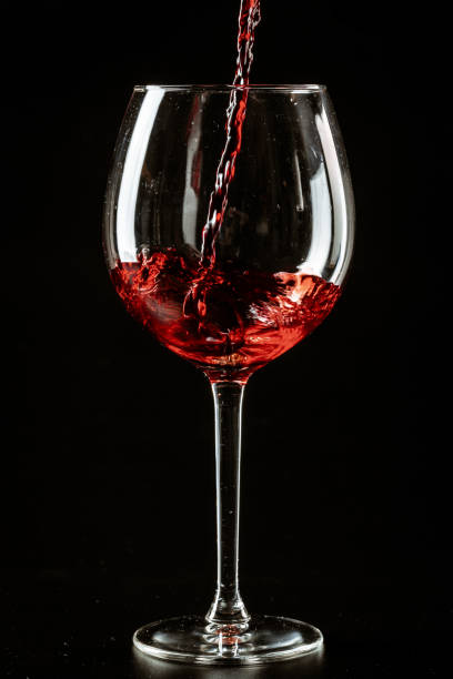 istock Red wine being poured in a wine glass on a dark background 1497530751