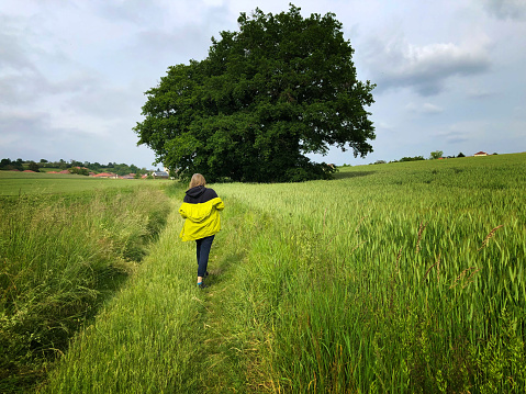 Woman Walking in Springtime Meadow with Big Tree (Isere, France)