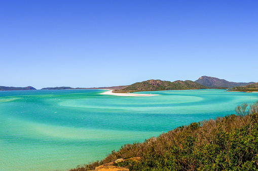 Panorama of iconic and amazingly beautiful Whitehaven Beach in the Whitsunday Coast, Queensland taken in summer time on a beautiful blue sky day.