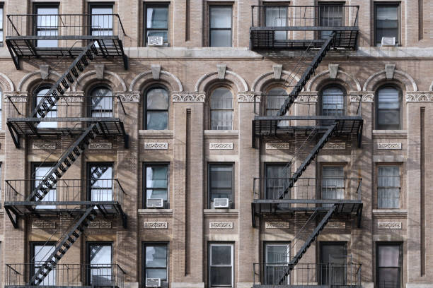 Old New York City Apartment building with external fire escape ladders stock photo