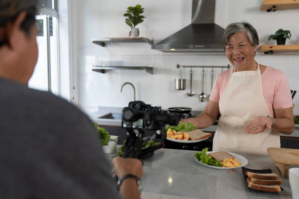 istock Female vlogger recording cooking related broadcast at home. 1497556817
