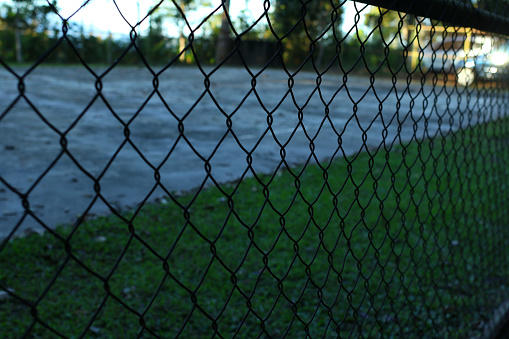 Mesh fence on an abandoned tennis court