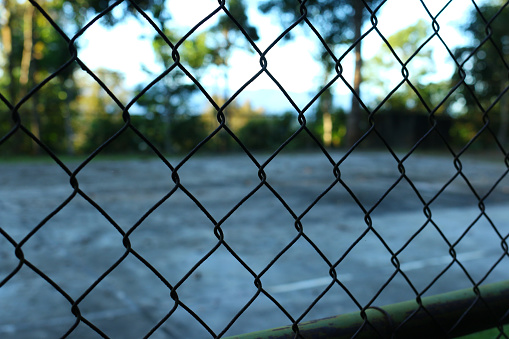Mesh fence on an abandoned tennis court