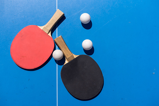 ping pong rackets and balls on a blue background, save space, sport and hobby