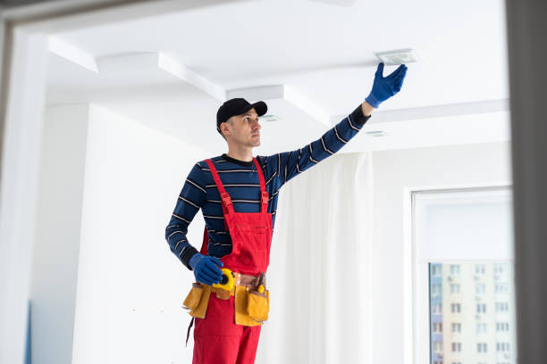 istock man plasterer construction worker at work, takes plaster from bucket and puts it on trowel to plastering the wall, wears helmet inside the building site of a house. 1497577000