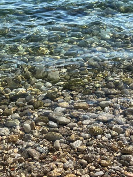 istock Sea water transparent surface in pebbles beach. 1497582037