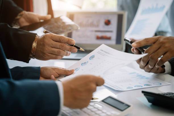 istock Teamwork process, Business team using a calculator to calculate the numbers of statistic business profits growth rate on documents graph data, desk in the office. 1497583547