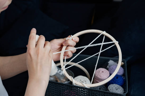 istock Weaving macrame at home. Hand of a woman when she is making macrame. 1497586324