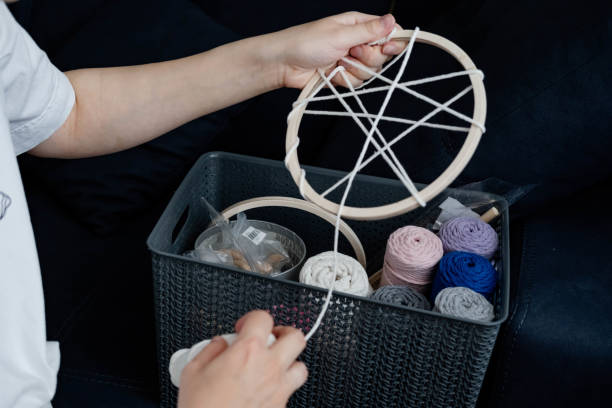 istock Weaving macrame at home. Hand of a woman when she is making macrame. 1497586326