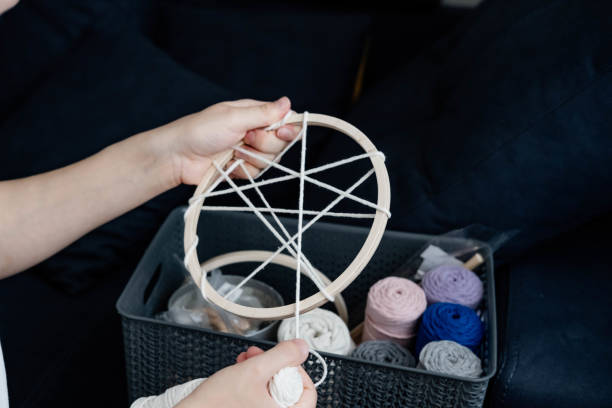 istock Weaving macrame at home. Hand of a woman when she is making macrame. 1497586467