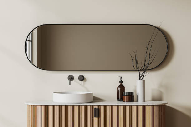 istock Cozy bathroom interior with washbasin and oval mirror, accessories on deck 1497589489