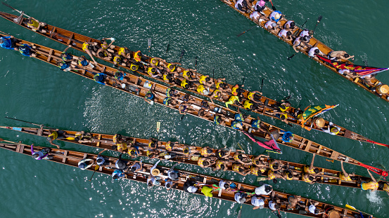 Cambridge, Massachusetts, USA - May 13, 2023: Overhead view of men rowing an eight man scull boat on the Charles River.