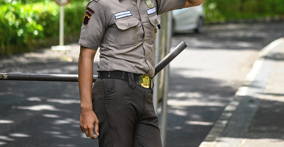Policeman or military policeman stands in front of a ramp in a street where entry is prohibited