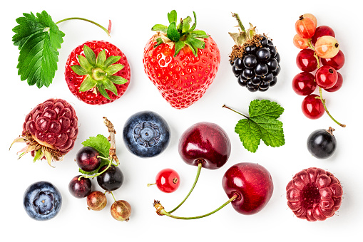 Different fresh berries isolated on white background. Healthy food concept. Strawberry, raspberry, blackberry, blueberry, leaves and currant creative layout. Top view, flat lay. Design element
