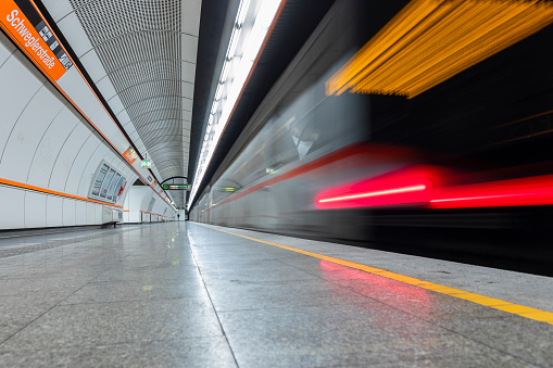 A subway train of the Vienna subway system is just leaving the subway platform.\nCanon EOS 5D Mark IV, 1, f/6,3 , 24 mm.