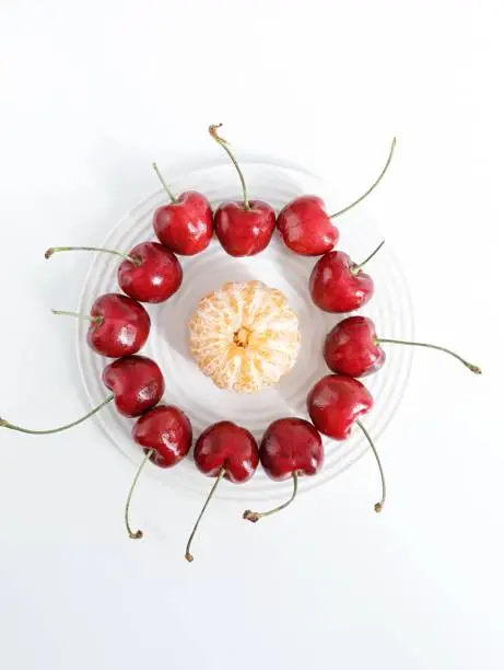A closeup of round-shaped cherries and mandarin