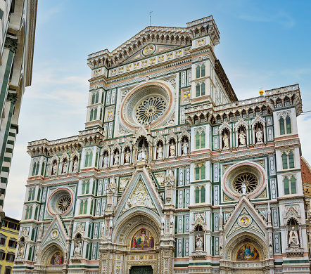 Facade of the Basilica of Santa Maria Novella in Florence, Tuscany, Italy. The church on blue sky background at summer. Florence is a popular tourist destination of Europe.