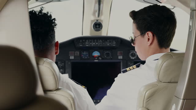 Private jet pilots going through checklist inside the cockpit