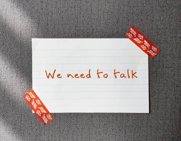 istock Note stick on office wallpaper with handwritten text - We Need To Talk  - concept of having difficult conversations to solve relationship conflict, workplace serious issues conflict discussion 1497613992