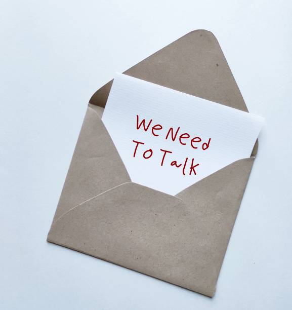 istock Craft envelope with card written - We Need to Talk - concept of having difficult conversations to solve relationship conflict, workplace serious issues conflict discussion 1497614010