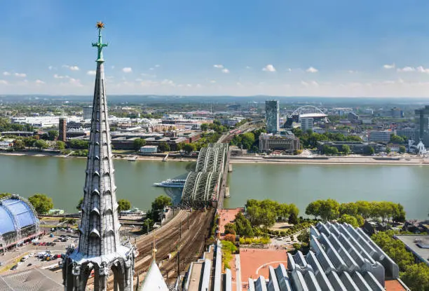 High angle view to the Hohenzollern Bridge and Rhine River in Cologne, Germany with the Cologne Cathedral in the foreground.