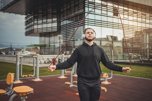 The young man trains outdoors in the gym in front of the business and residential complex, which has its own section for tenants and employees in that part of the building.