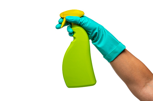 Woman's hand wearing washing glove holding spray bottle