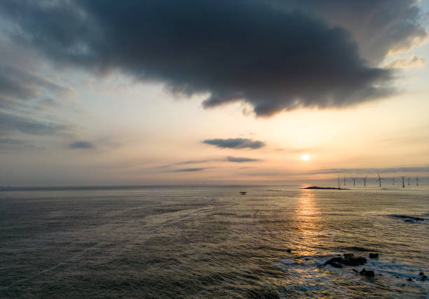 A wind farm in the distance atop covered by black clouds