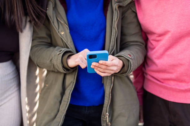 istock hands of a woman using smart phone with friends 1497643725
