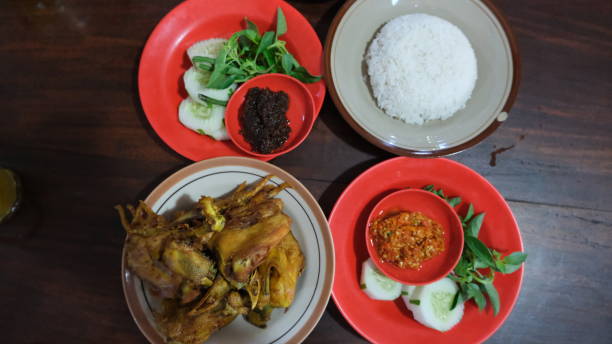 istock Indonesian traditional fried chicken served with with chili paste, fresh raw vegetables and rice 1497646894