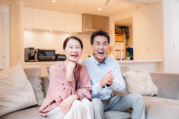 家でテレビを見ている老夫婦 - document lifestyles senior couple female ストックフォトと画像